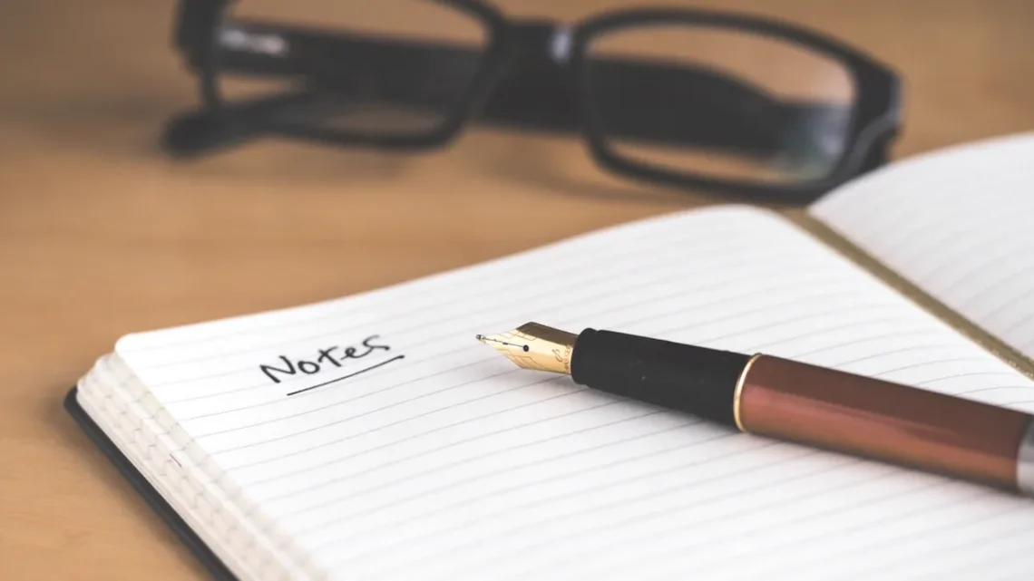 morning routine template: open daily planner notebook and pen resting on clean wooden desk