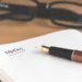 morning routine template: open daily planner notebook and pen resting on clean wooden desk